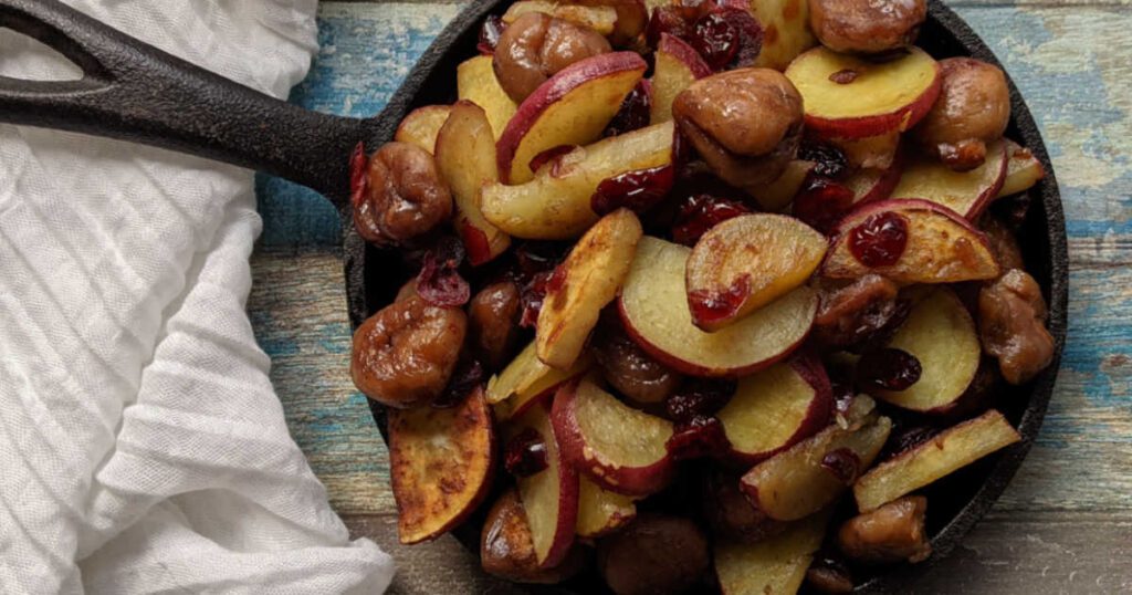 8 Traditional Christmas Flavors Cast-iron skillet with roasted sweet potatoes, chestnuts, and cranberries