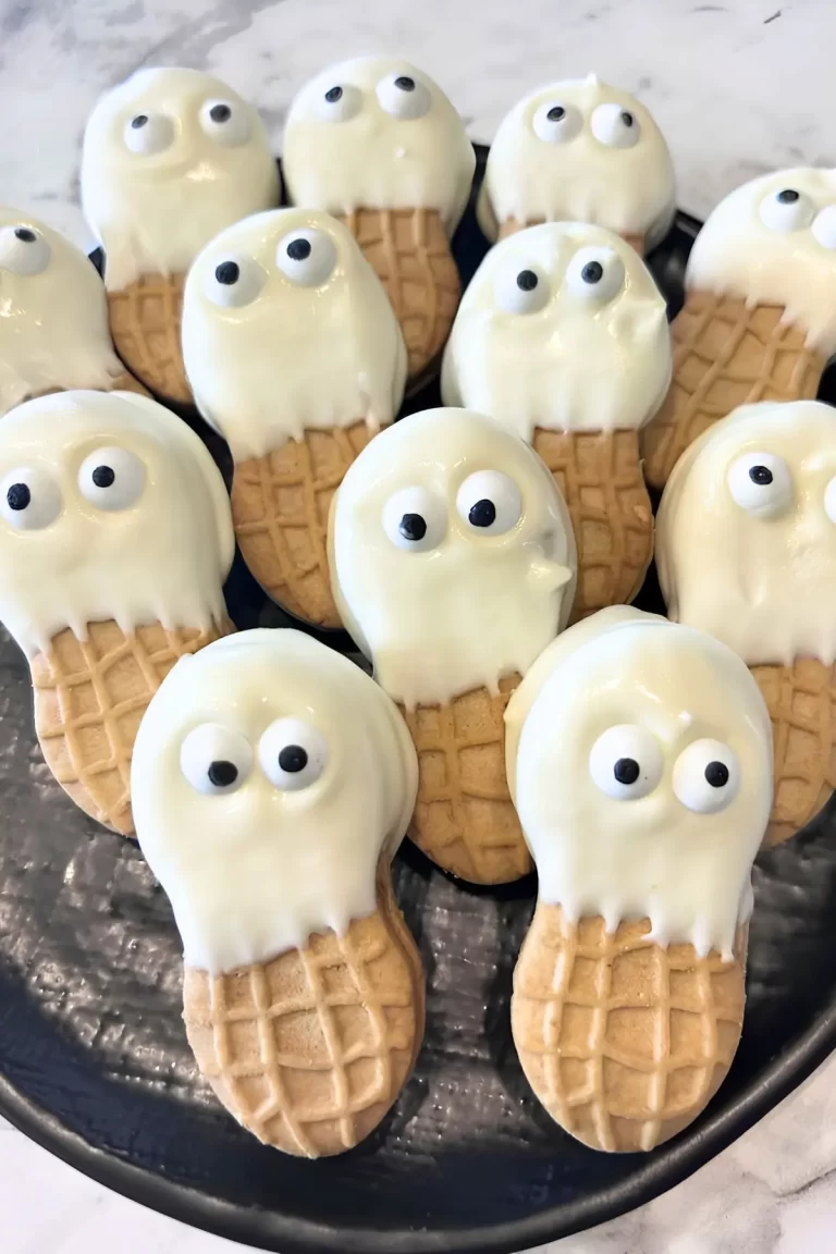 Easy Nutter Butter ghost cookies dipped in white chocolate with candy eyes, perfect for Halloween