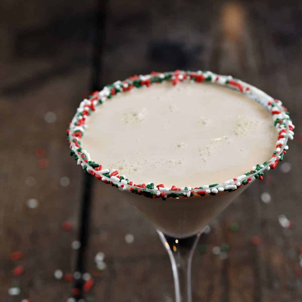 11 Christmas Cocktails with Baileys Christmas martini cocktail with red, white and green sprinkle rim
