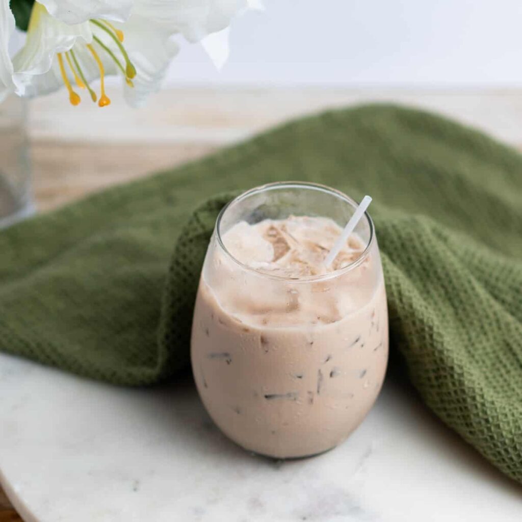 11 Christmas Cocktails with Baileys Creamy iced coffee in stemless glass with straw on marble surface
