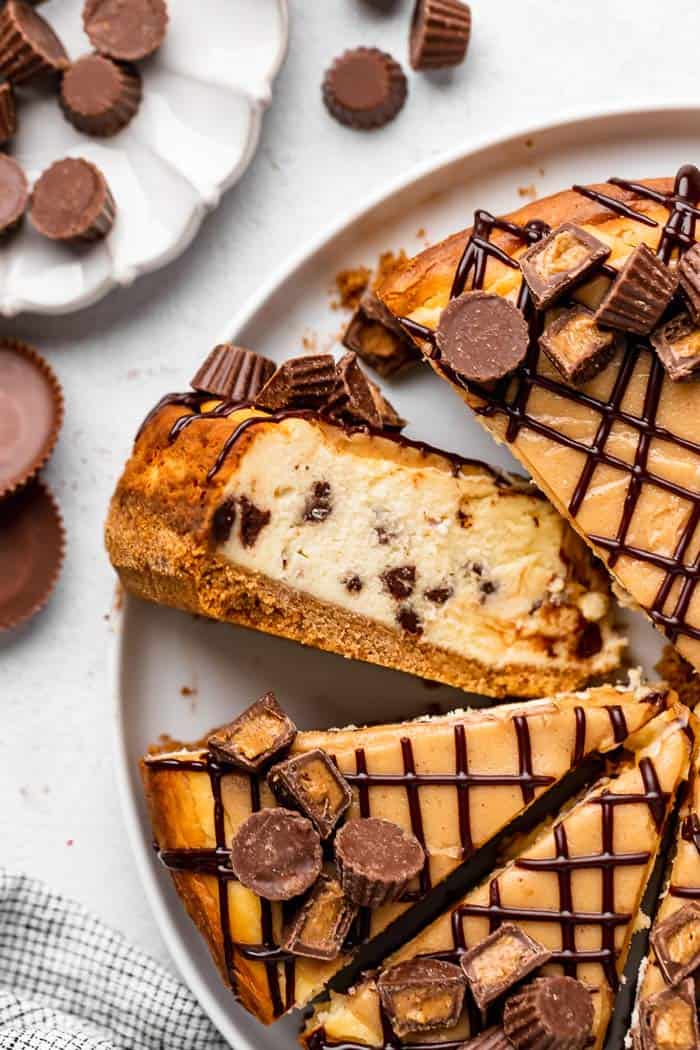A sliced peanut butter cup cheesecake on a platter.
