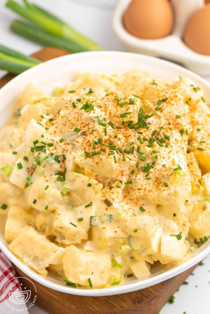 A white bowl of deviled egg potato salad.