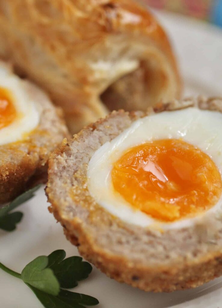Halved Scotch egg with soft-boiled yolk and crispy sausage coating