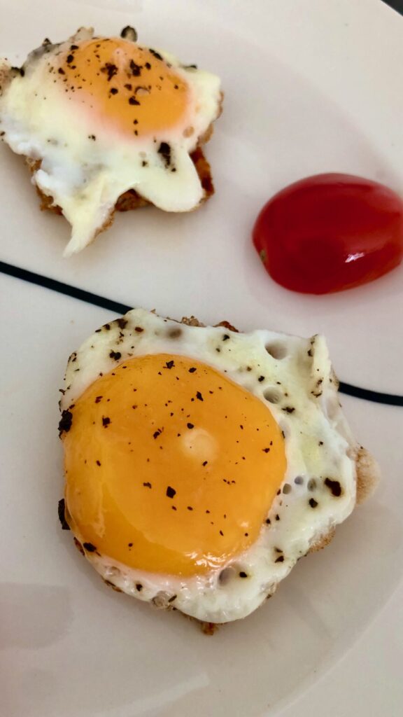 A white plate of mini fried eggs.