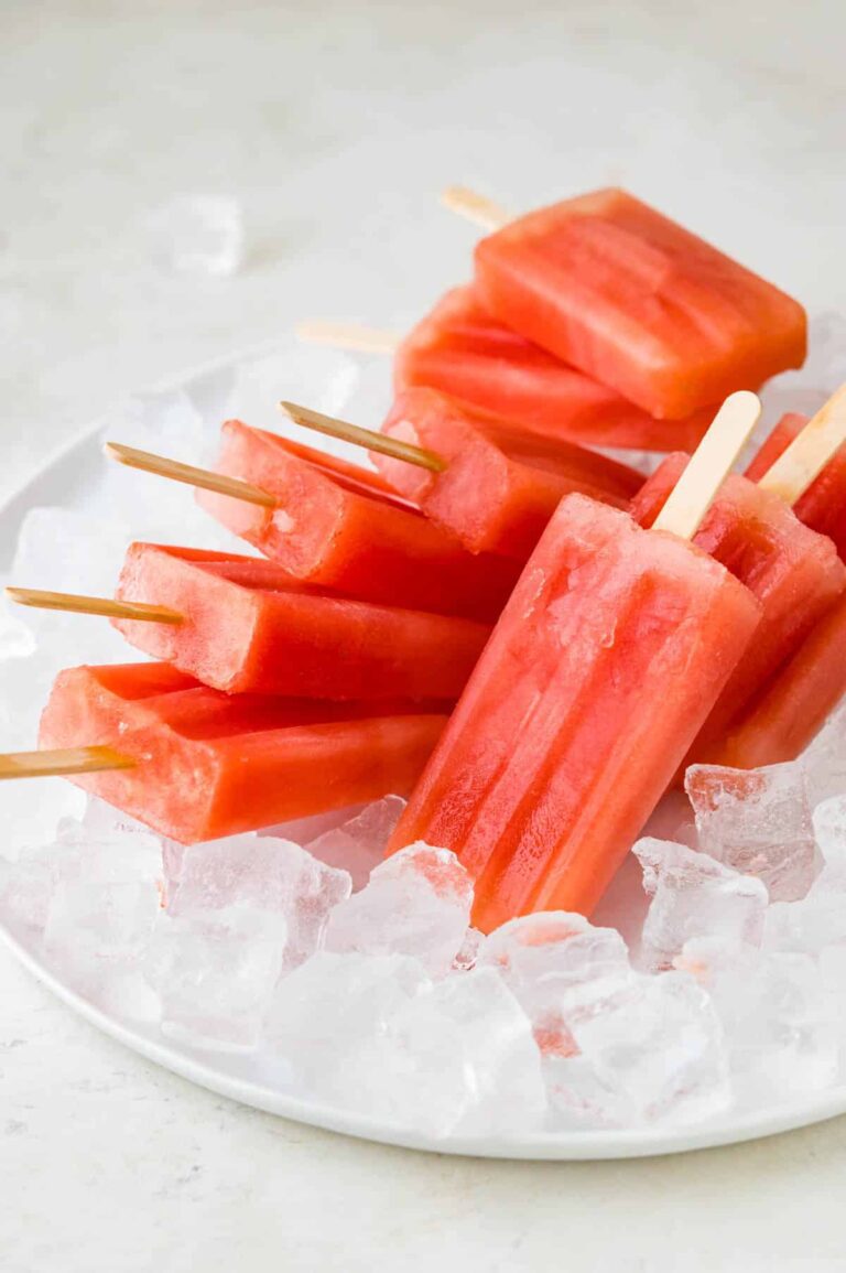 A group of sugar free popsicles in ice cubes on a white plate.