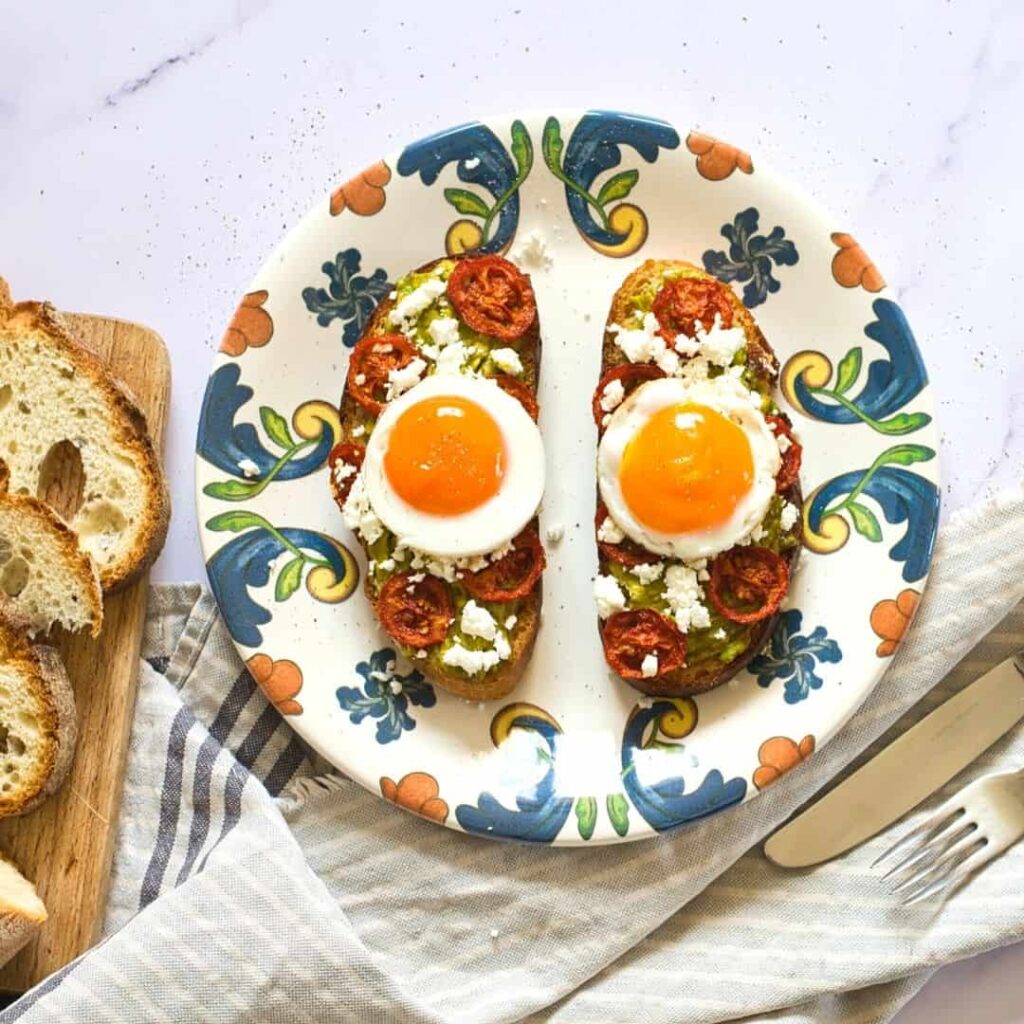 Sourdough toast with sunny-side eggs, feta and roasted tomatoes