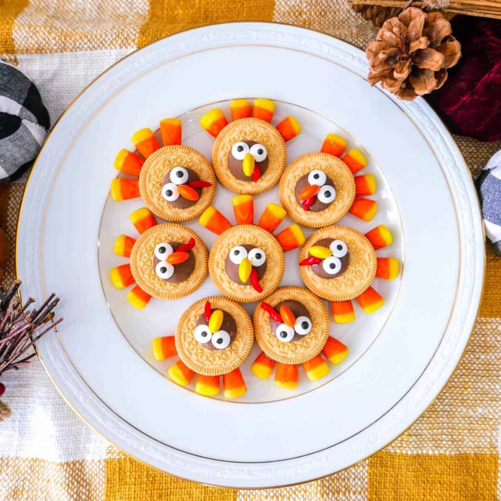 8 Delectable Turkey Desserts for Thanksgiving Oreo turkey cookies with candy corn feathers on a white plate