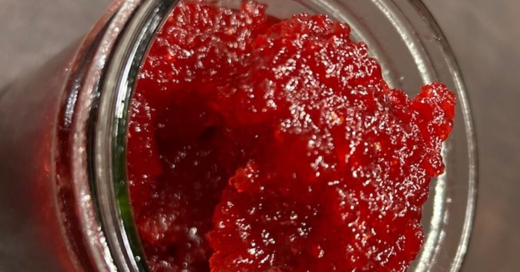 A close up picture of Christmas jam being spooned out of a jar.