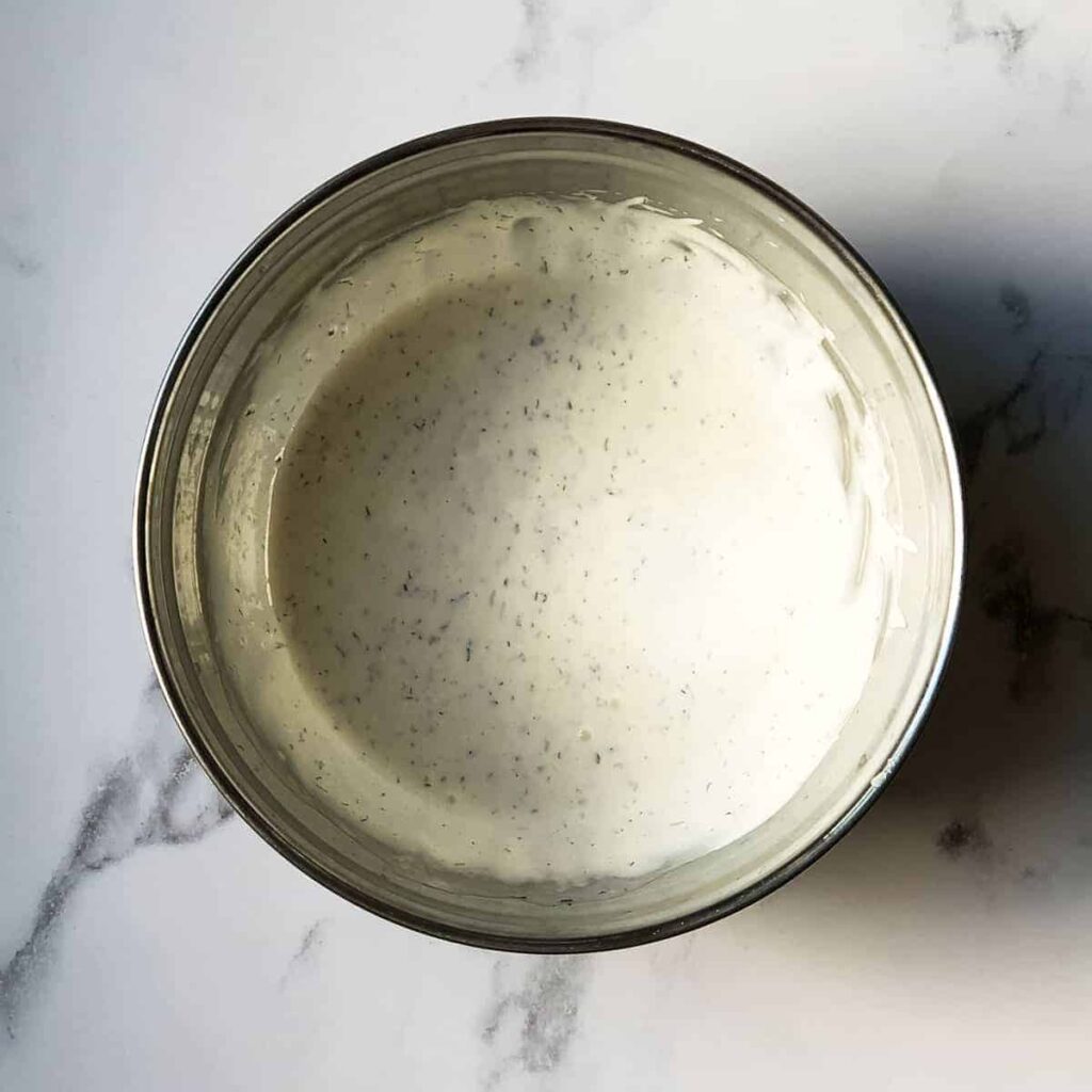 8 Irresistible Buffalo Wild Wings Copycat Recipes Homemade creamy ranch dressing in a metal bowl on marble countertop