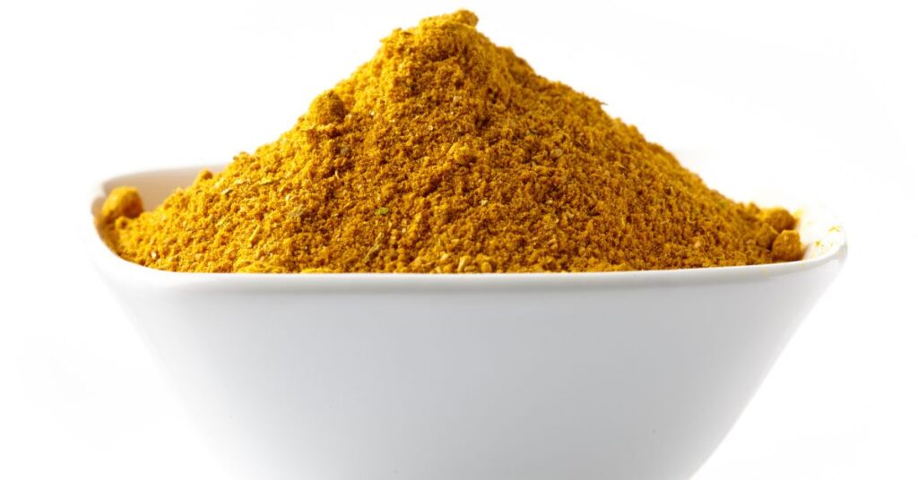 Curry Powder, a homemade spice blend, in a white bowl.