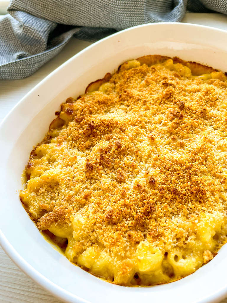 Beer mac and cheese in a white casserole dish with a crispy breadcrumb topping.