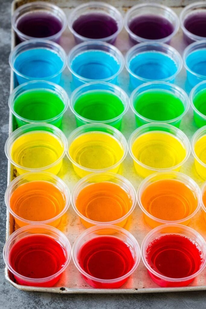 6 New Year's Eve Shots Rainbow Jell-O cups arranged in rows on a tray