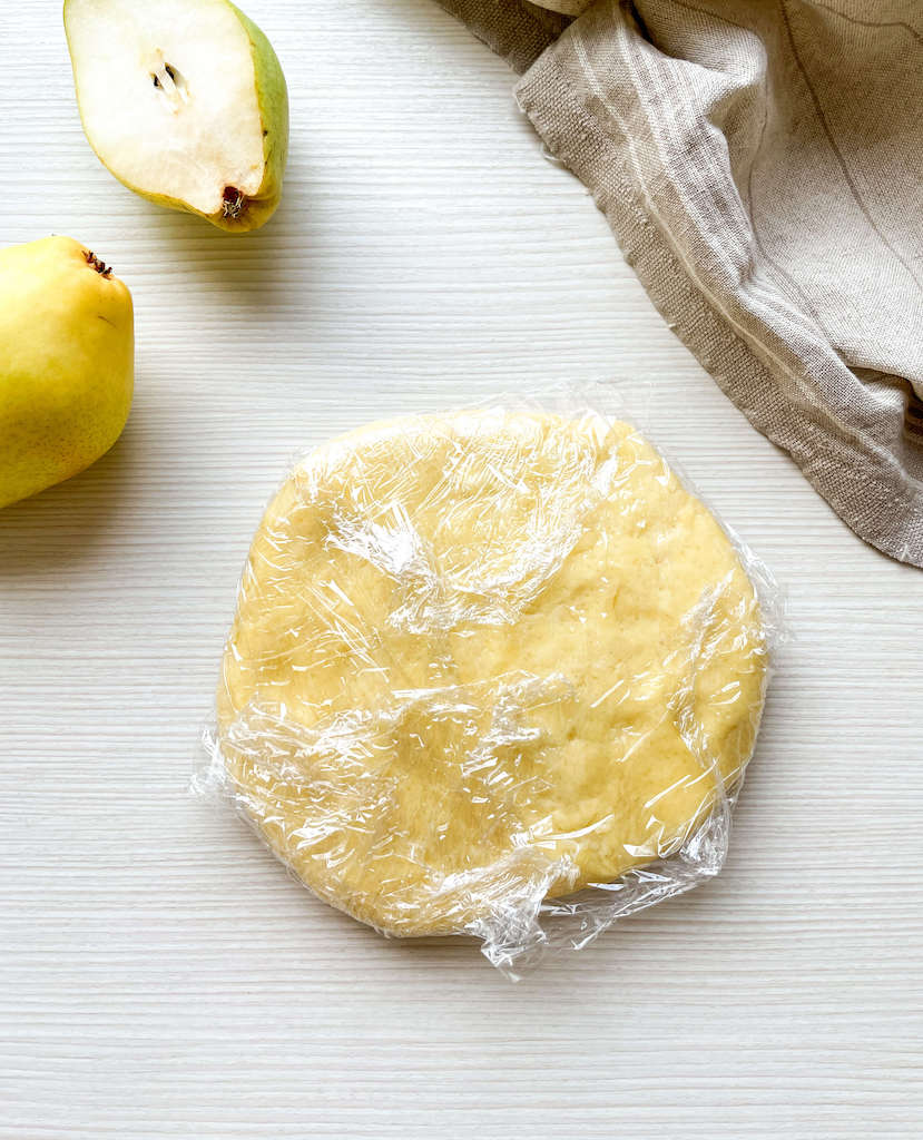 A disc of the dough wrapped in plastic wrap ready to be chilled in the fridge.