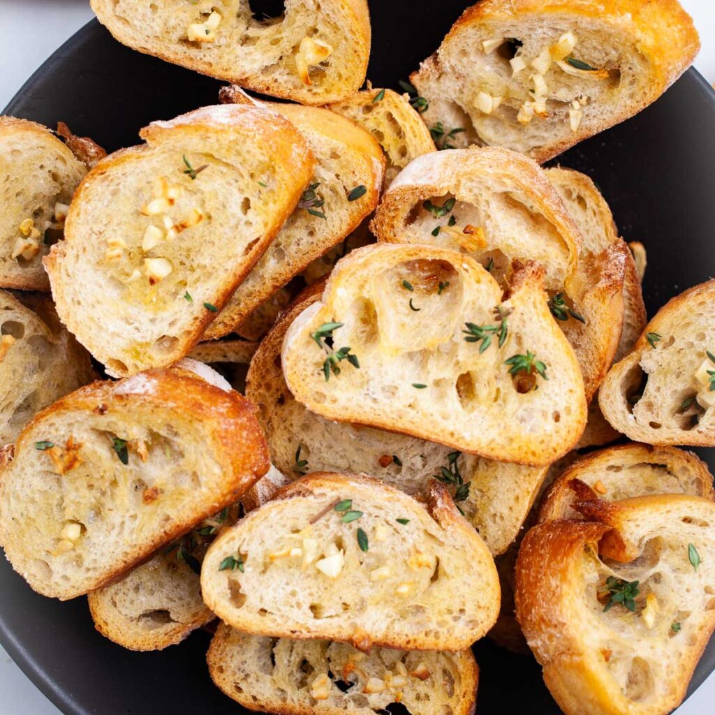 Toasted baguette crostini with garlic and thyme herb appetizer