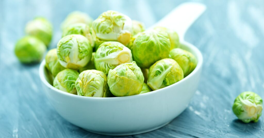Brussel sprouts in a white bowl for making atomic frog balls.