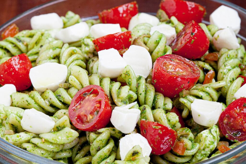 Caprese pesto pasta salad with rotini, cherry tomatoes, and mozzarella