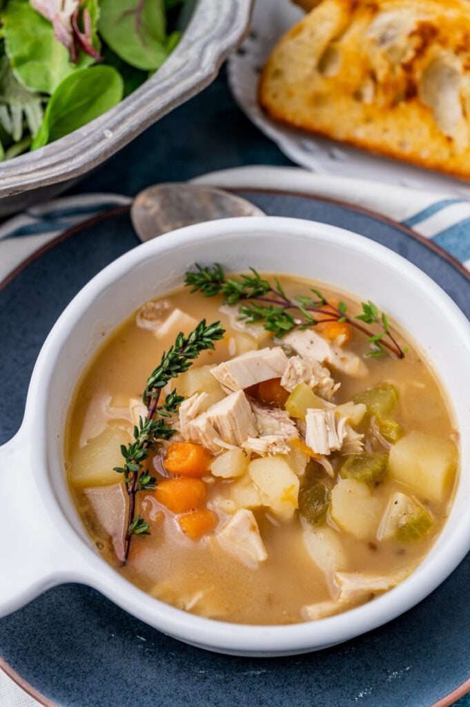 Hearty chicken vegetable soup with potatoes, carrots, celery, and thyme