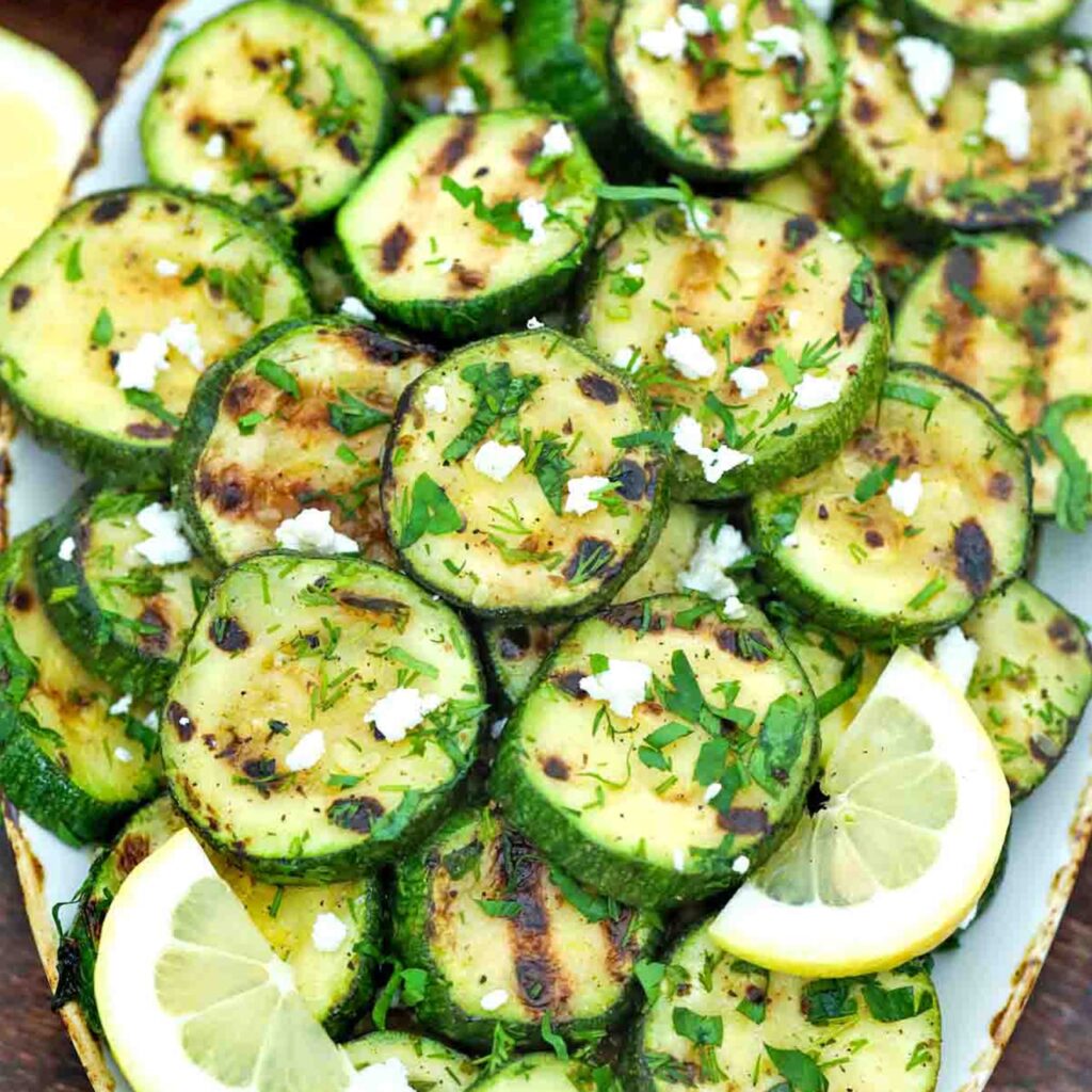 Grilled zucchini slices with fresh herbs, feta and lemon