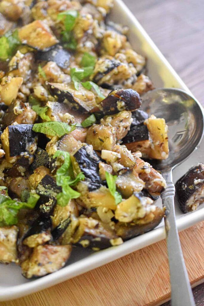 Roasted eggplant with garlic, herbs and cheese in serving dish