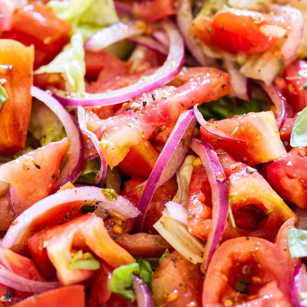 Close-up of fresh tomato and red onion salad with basil and vinaigrette