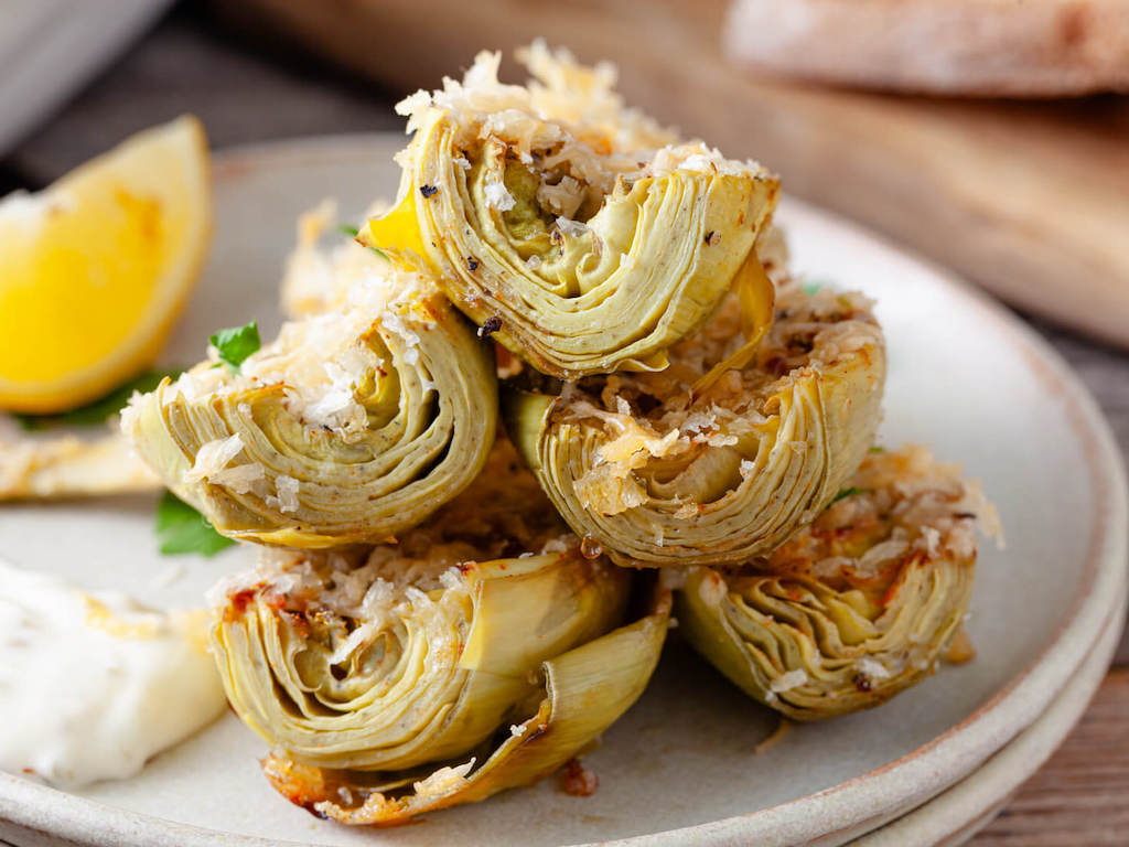 Recipe Index A serving of crispy artichoke hearts on a plate garnished with a lemon wedge.