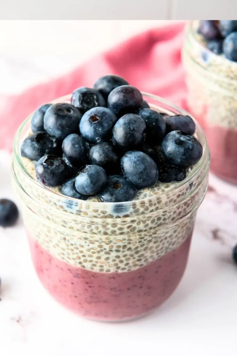 Layered blueberry chia seed pudding in a jar, topped with fresh blueberries