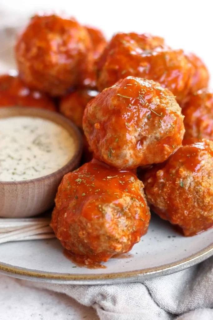 Juicy buffalo turkey meatballs coated in spicy buffalo sauce, paired with a creamy dipping sauce for a bold flavor experience.