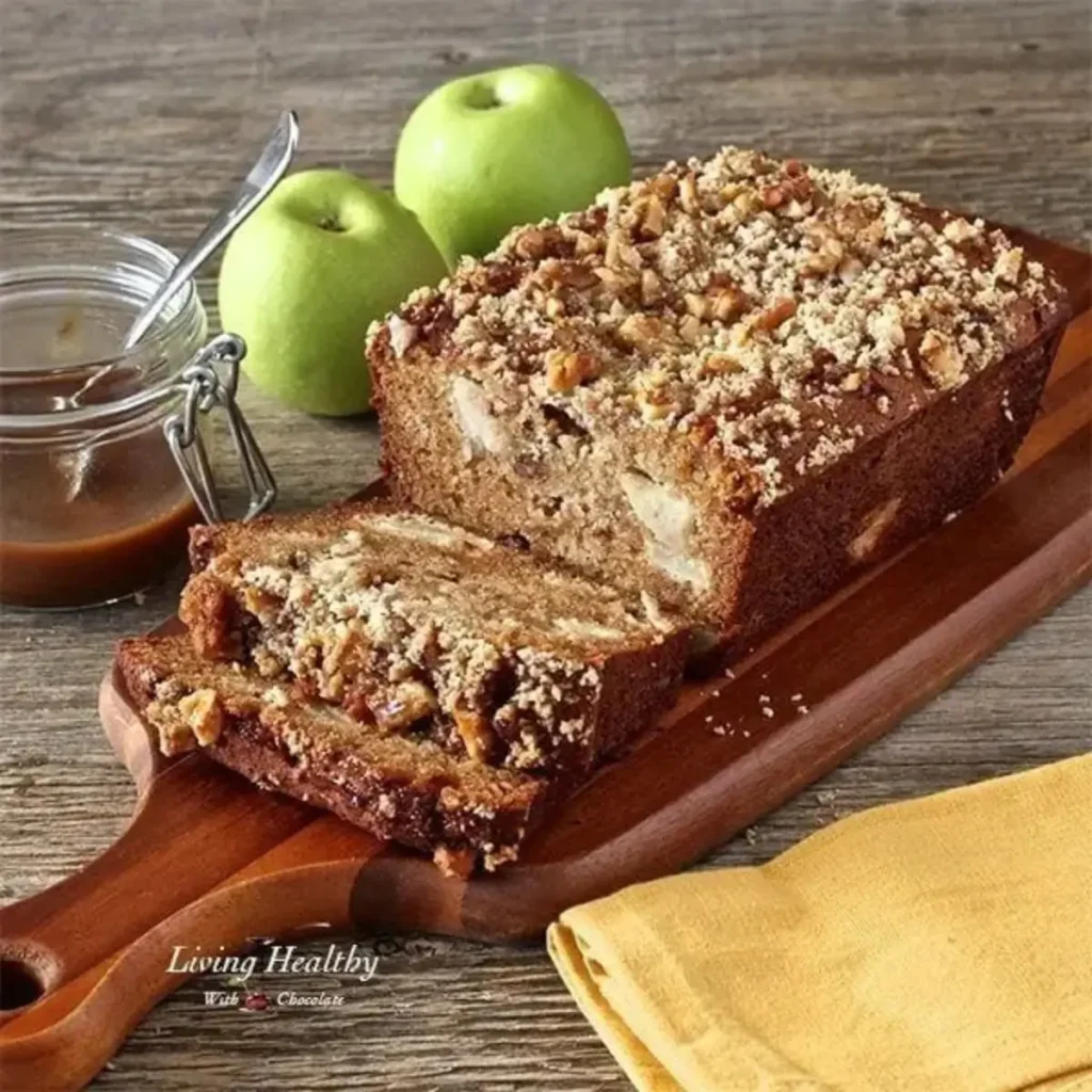 A loaf of caramel apple pie bread made with almond flour, topped with a crumble and fresh apples. This gluten-free treat is perfect for fall gatherings or a cozy dessert.  