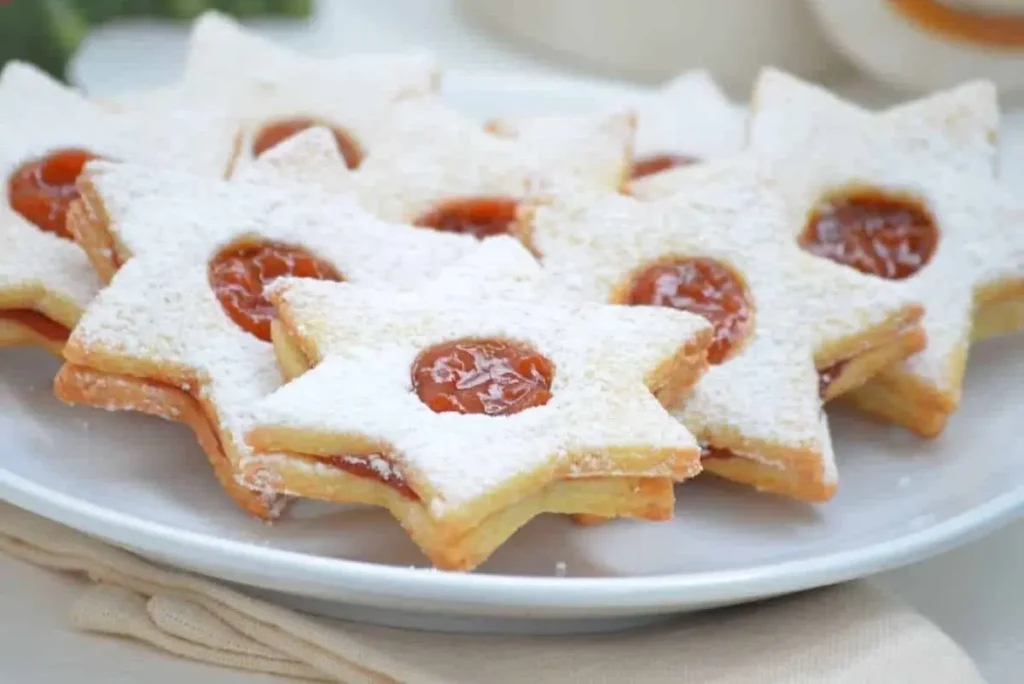 Traditional Austrian Linzer cookies made with almond flour and filled with fruity jam, a gluten-free festive treat.