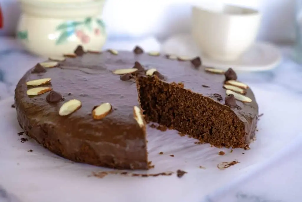 A moist and fluffy chocolate almond flour cake decorated with almond slices and chocolate chips, perfect for gluten-free and keto dessert lovers.