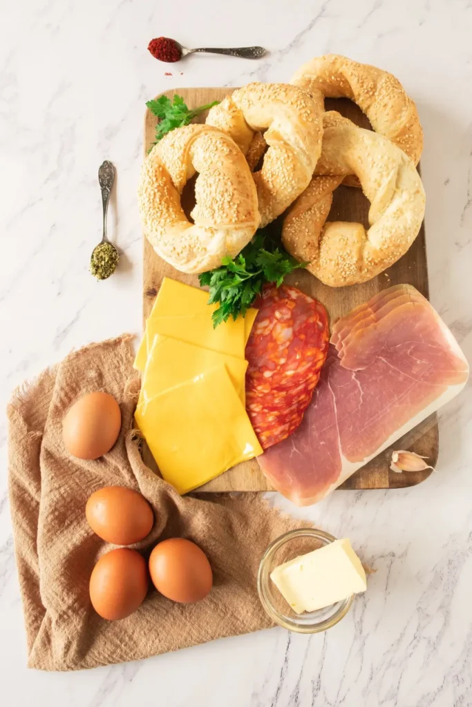 Ingredients for savory bagel breakfast with egg, prosciutto, and Italian salami, a quick and easy breakfast idea.