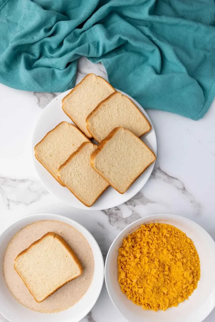 Thick slices of Texas toast bread being dipped into a cinnamon-infused egg mixture for the best French toast recipe.