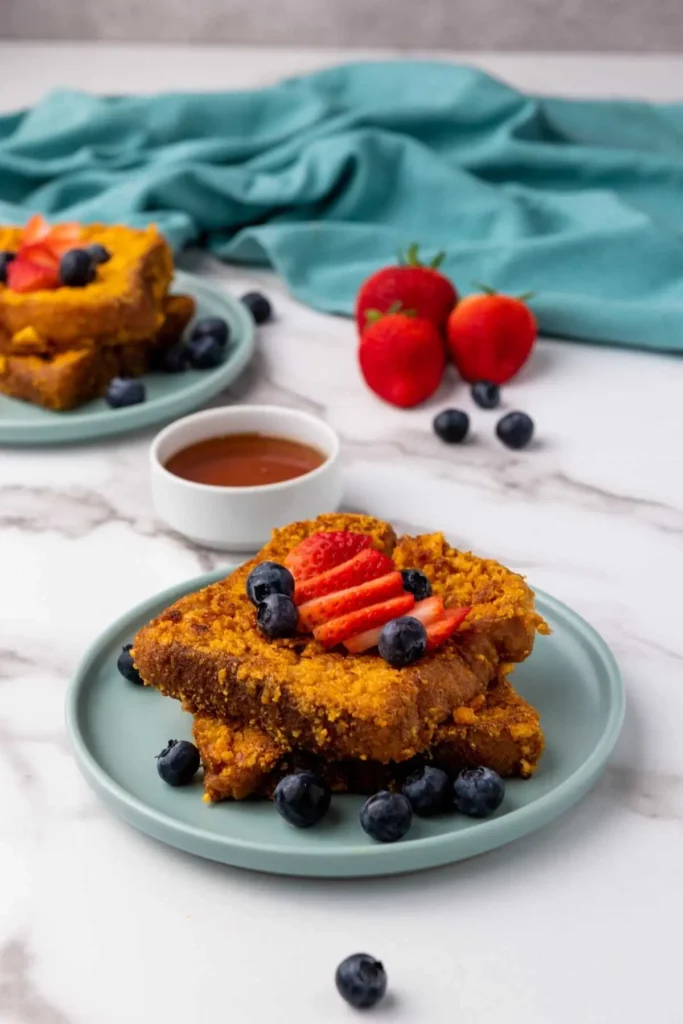 Golden, crispy Cap’n Crunch French Toast served with syrup and fresh berries – the ultimate French toast with Texas toast bread.