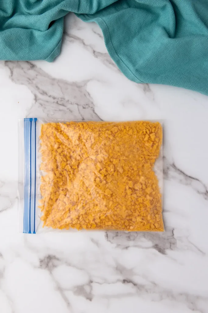 Crushing Cap’n Crunch cereal in a Ziploc bag with a rolling pin – the first step to making crunchy French toast.