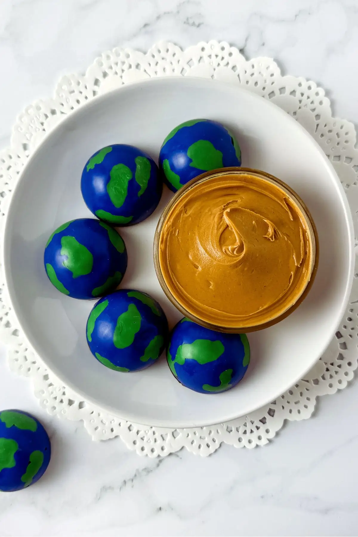Globe chocolate truffles with peanut butter dip on a white plate