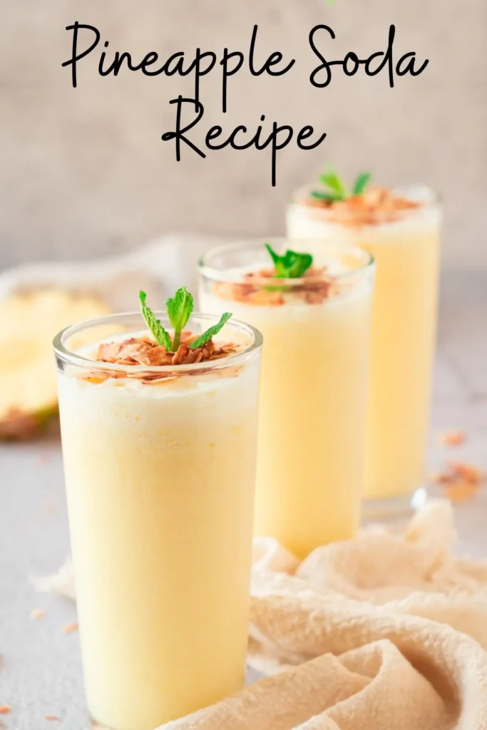 Tropical pineapple smoothies topped with toasted coconut and fresh mint, served alongside a ripe pineapple.