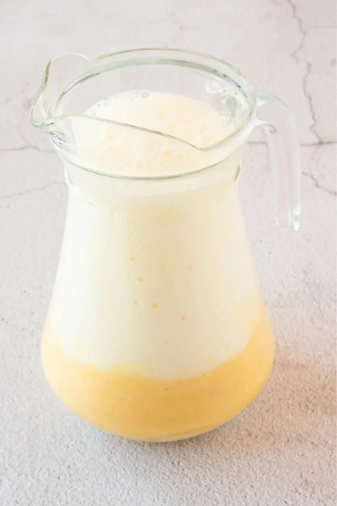 A pitcher of homemade pineapple soda, showcasing the creamy texture and vibrant color of this fruit soda drink. An easy recipe for a refreshing nonalcoholic beverage.