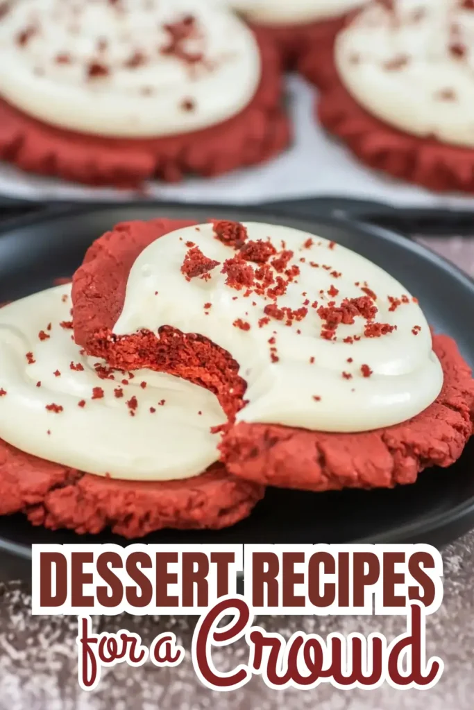 Red velvet cookies topped with cream cheese frosting and crumbs on a plate, perfect for crowds