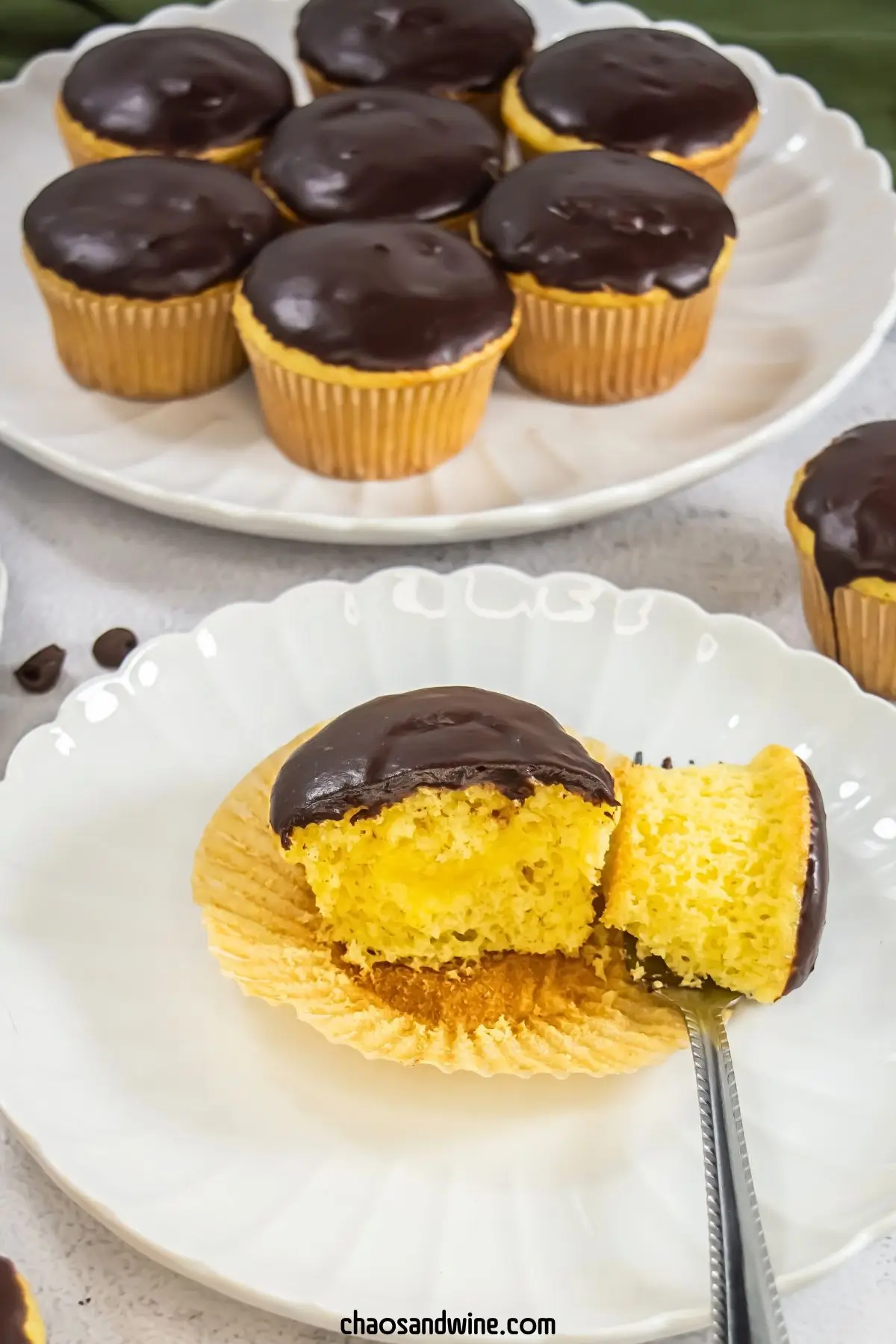 Boston Cream Pie Cupcakes Cross-section of a boston cream pie cupcakes showing creamy vanilla center and chocolate topping