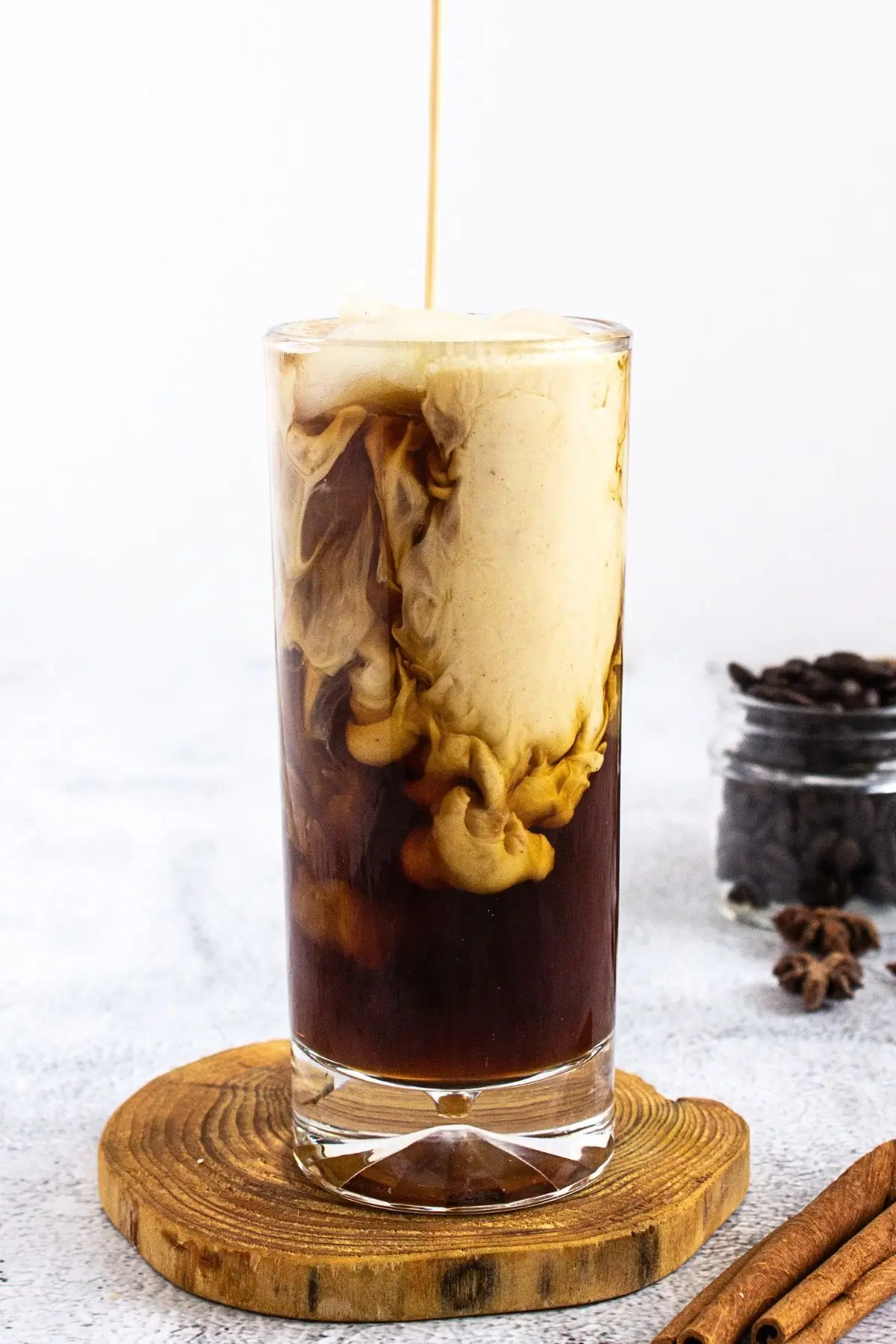 Homemade Cinnamon Vanilla Creamer (Cinnabon-Style) Tall glass of iced coffee with homemade cinnamon flavored coffee creamer swirl
