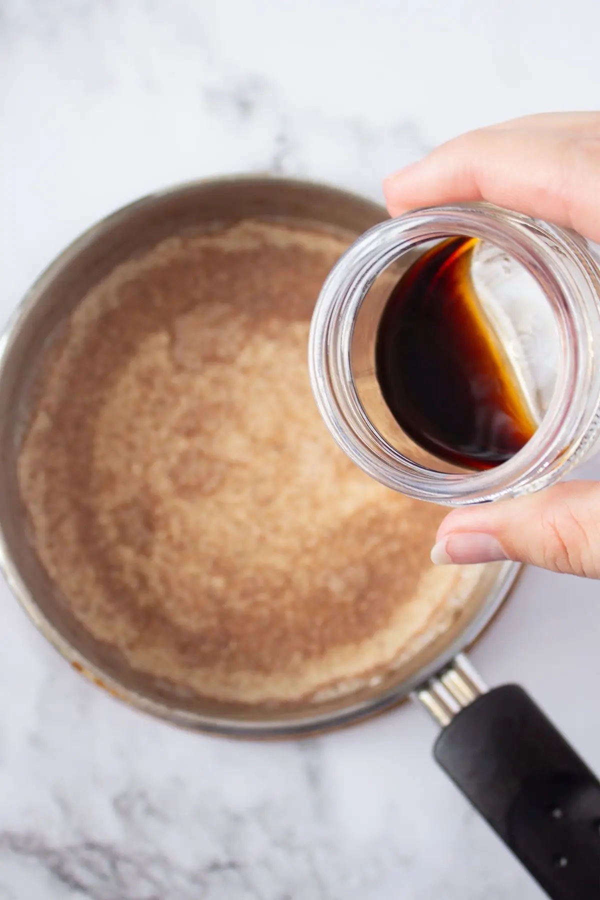 Homemade Cinnamon Vanilla Creamer (Cinnabon-Style) Hand pouring rich vanilla spice creamer into a saucepan