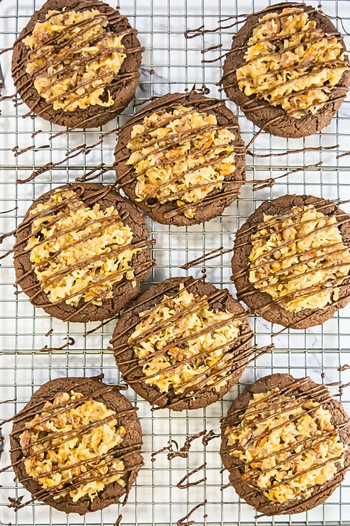 German Chocolate Cake Crumbl Cookies Homemade Crumbl German chocolate cake cookies on a wire rack, perfect copycat recipe with gooey frosting and bakery-style chocolate drizzle.