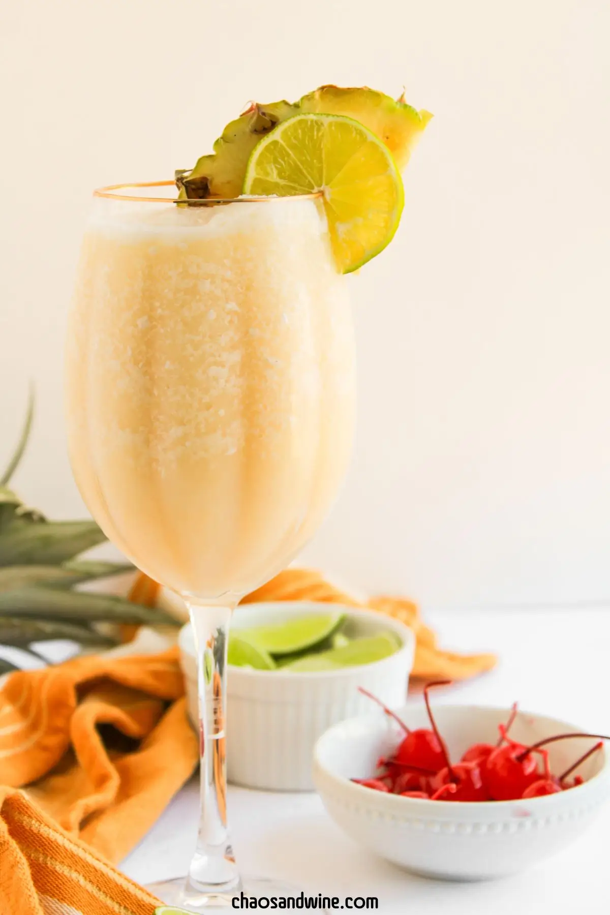 Virgin Pina Colada Mocktail - only 3 Ingredients Virgin cocktail in a tall glass with pineapple pieces, a maraschino cherry, and a lime slice on top