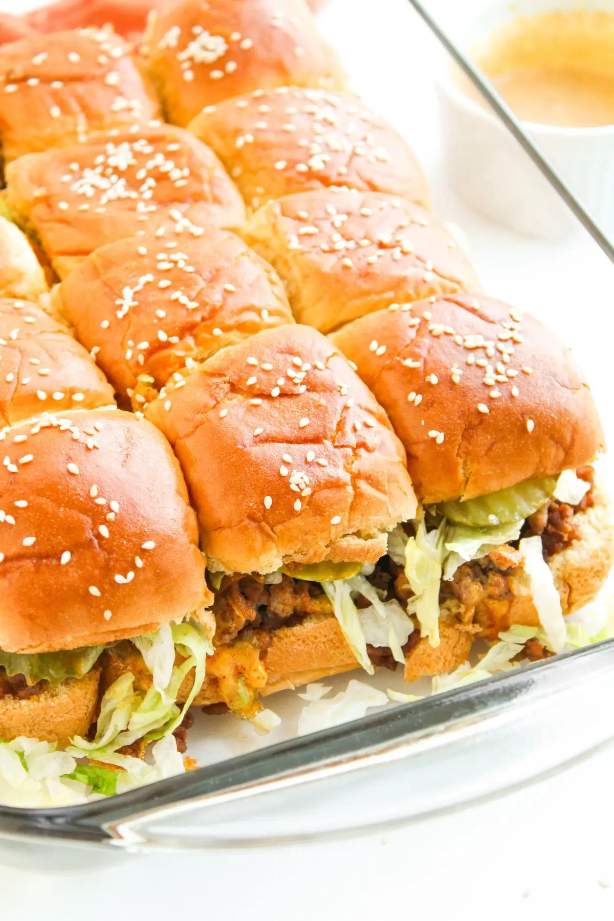 The Best Big Mac Sliders Big Mac Sliders baked in a glass dish with sesame-topped buns