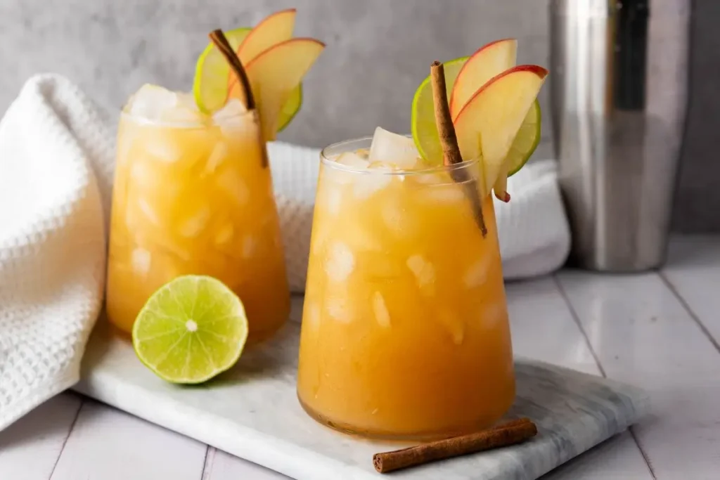 Easy Non Alcoholic Drinks for Parties with Friends Apple cider margaritas with lime, cinnamon and ice on marble board