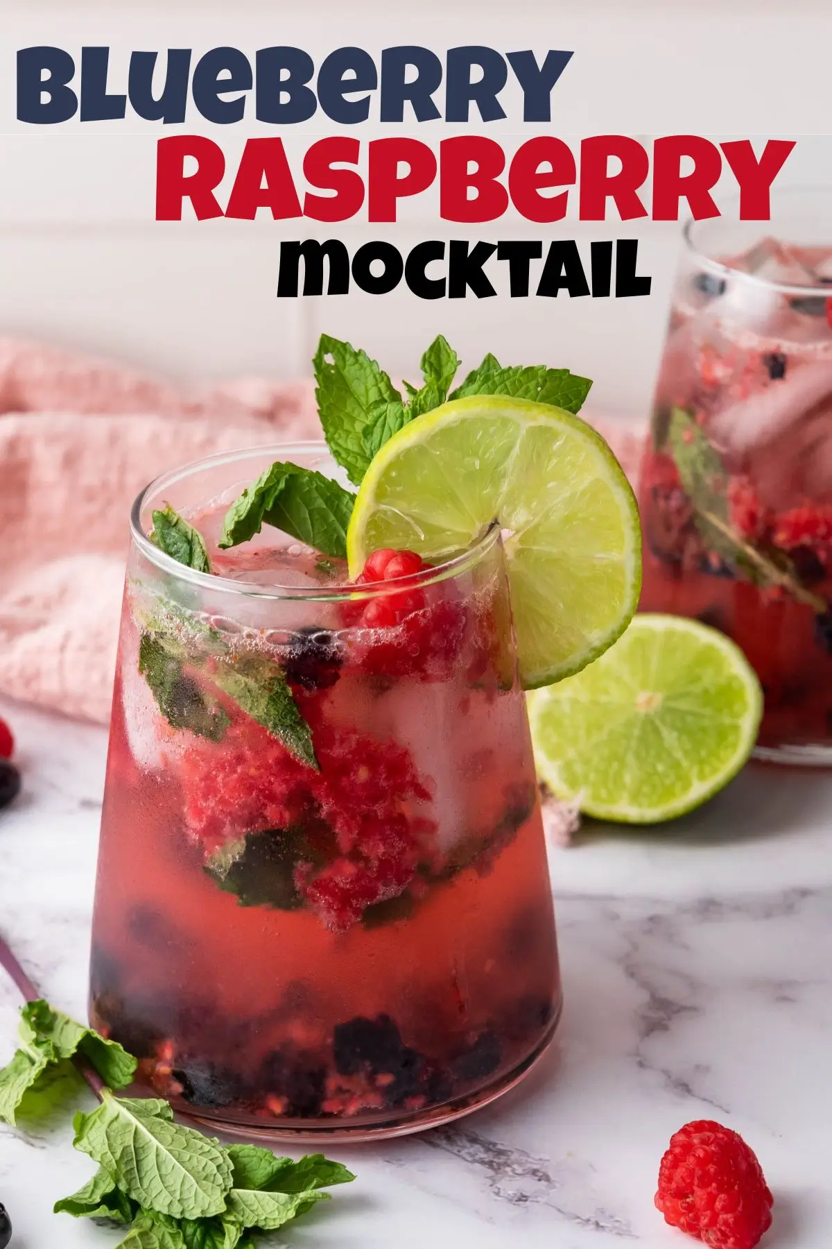 blueberry raspberry mint mocktail with a mint sprig and lime wedge on top