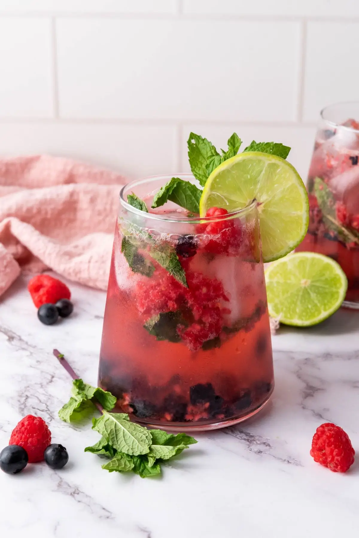 Two glasses of refreshing summer mocktail with blueberries and mint, a party mocktails for kids on a table at a fun family gathering.