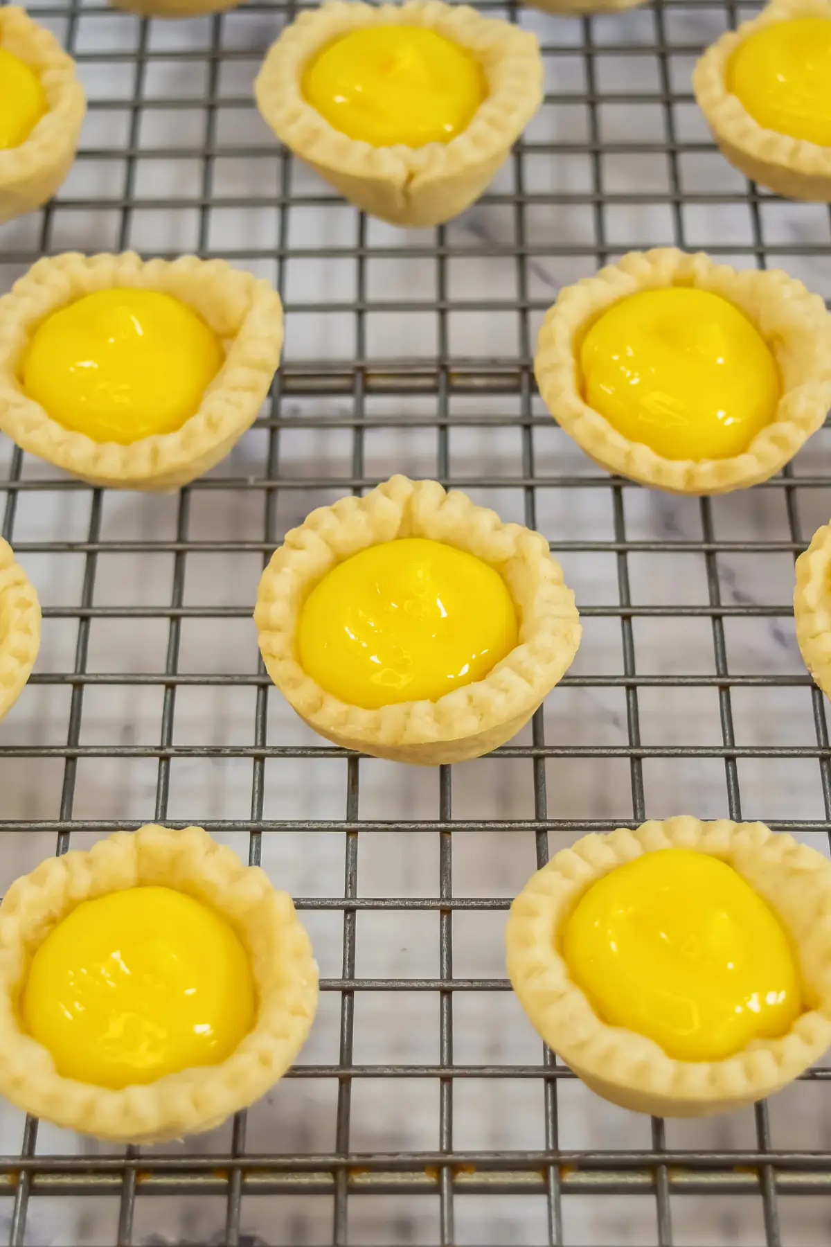 Easy Lemon Tartlets with Lemon Curd baked tarts filled with lemon curd on a cooling rack