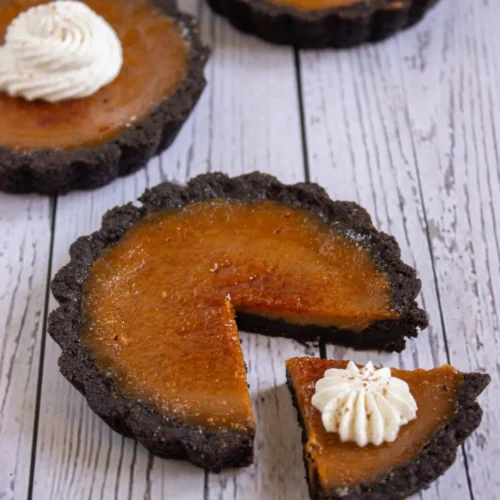 Pumpkin tart recipe with chocolate crust and whipped cream topping, delicious pumpkin creme brulee tartlets for easy fall desserts.
