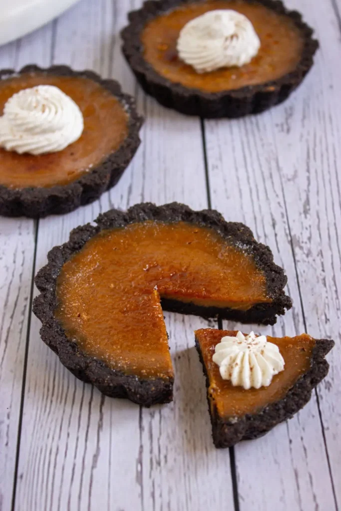 Pumpkin tart recipe with chocolate crust and whipped cream topping, delicious pumpkin creme brulee tartlets for easy fall desserts.